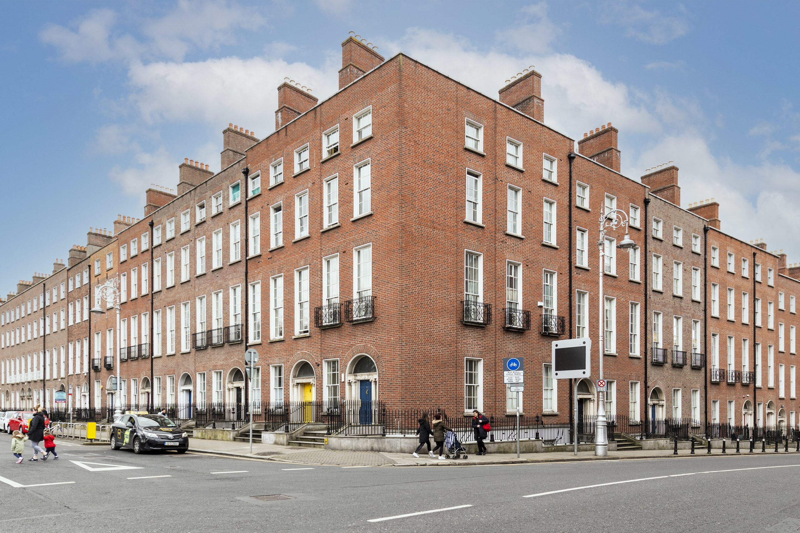 Expert Removals A red brick building with people walking in front of it.