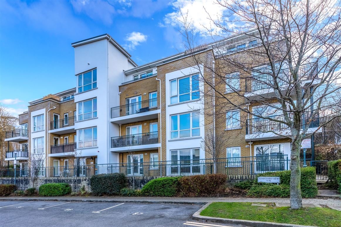 Expert Removals A large apartment building with balconies and trees.